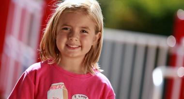 young girl in pink tshirt smiling