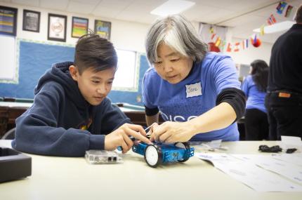 Mentor works with youth on robot.