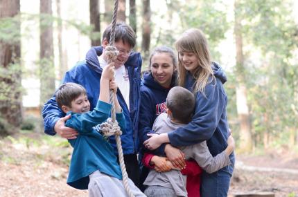 smiling family having just done a rope swing activity