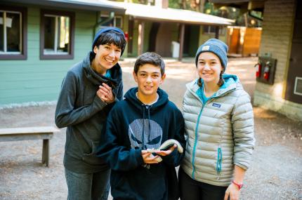 boy and two teachers holding a snake