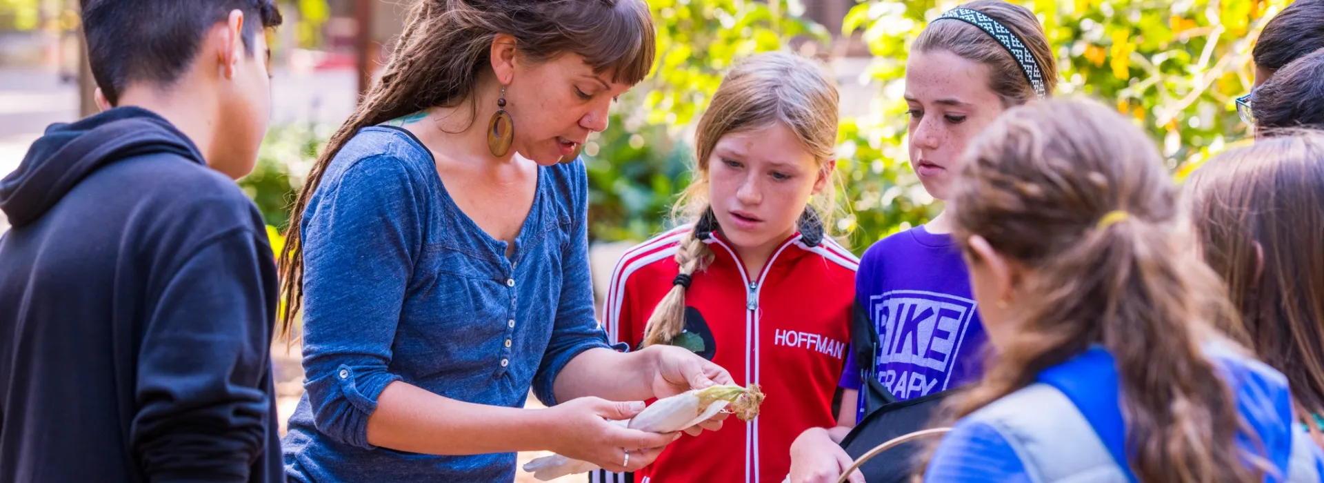 kids looking at corn with instructor